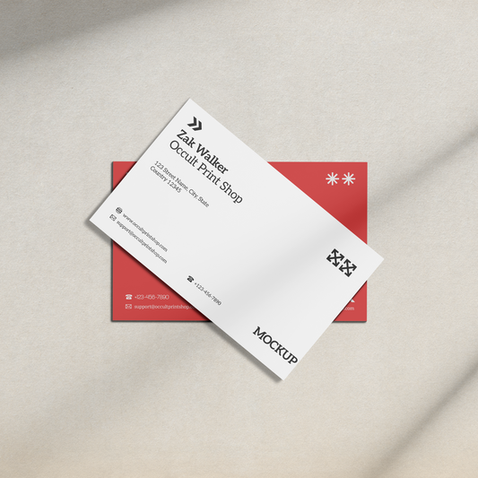 White business card with black text and red border on a beige surface.