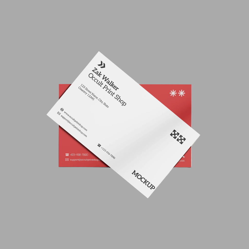 A white business card mockup layered diagonally over a red rectangular card, shown on a plain gray background. The front card includes black text, logos, and contact details, with the word MOCKUP printed near the bottom.