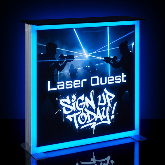 A rectangular LED light box sign with a glowing blue border and a dark graphic insert featuring silhouettes of people with laser pointers and the text 'Laser Quest' and 'SIGN UP TODAY!'.