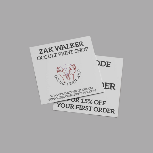 Two white printed business cards for Zak Walker Occult Print Shop, one showing the main logo and website, and the other partially showing a discount offer, set against a solid gray background.