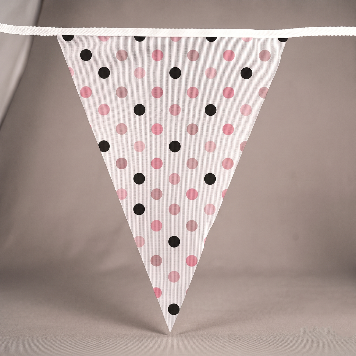Close-up of custom triangle bunting with pink and black polka dot printed pennants.
