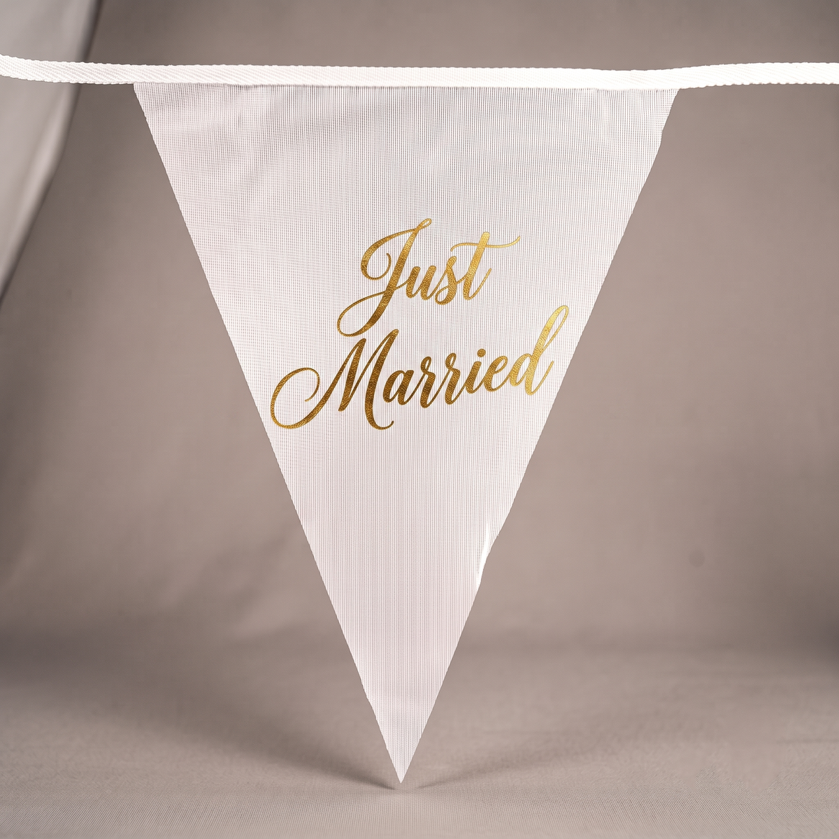 Close-up of personalised Just Married wedding triangle bunting printed on individual pennants.