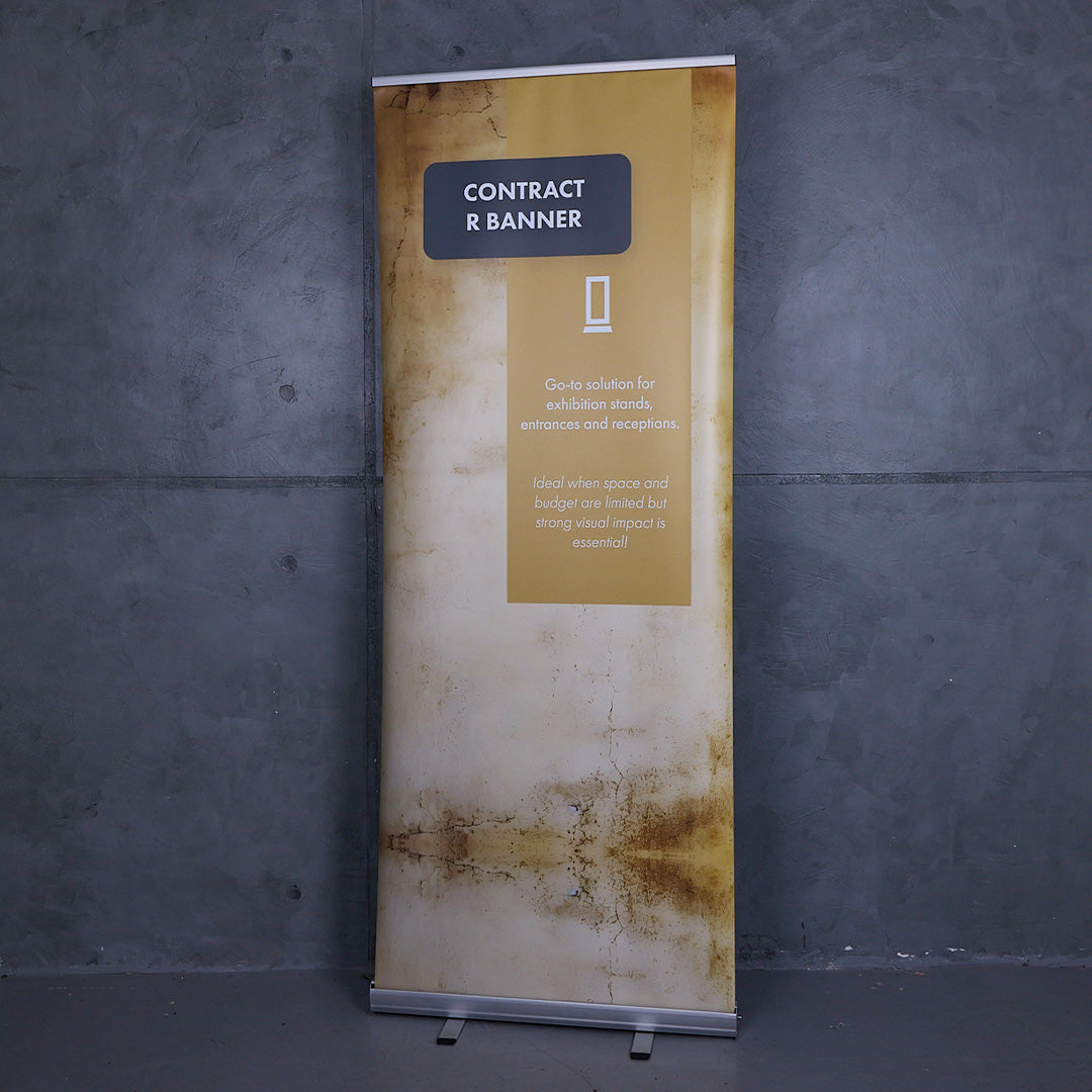 Professional roller banner displayed with a printed graphic against a grey wall